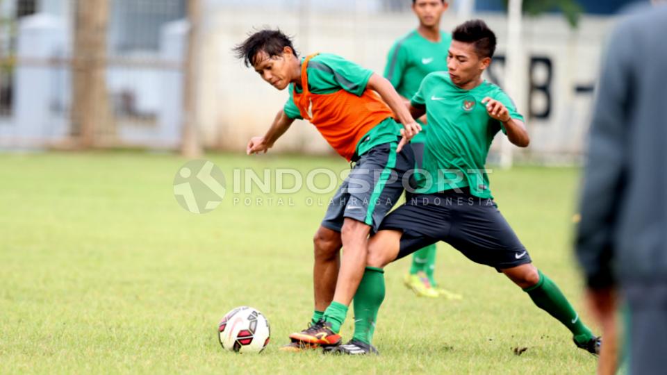 Pemain tengah Timnas U-22 Adam Alis Setyano (kiri) dijaga ketat oleh rekannya Ahmad Noviandani. 
